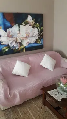 a pink couch in a living room with a painting at Little Umhlanga in Pretoria