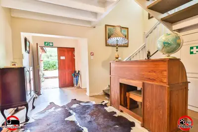 a living room with a piano and a fireplace at Cinzaco Dullstroom in Dullstroom