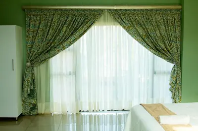 a bedroom with a bed and a window with curtains at Vakhusi Guesthouse in Malamulele