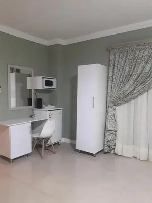 a kitchen with a refrigerator and a desk and a microwave at Vakhusi Guesthouse in Malamulele