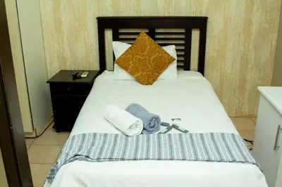 a bedroom with a bed with towels on it at Vakhusi Guesthouse in Malamulele