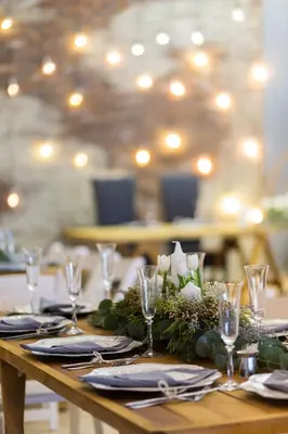 a wooden table with white flowers and glasses on it at Loskop Valley Lodge in Groblersdal
