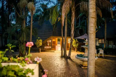 a resort with palm trees in front of a building at Loskop Valley Lodge in Groblersdal