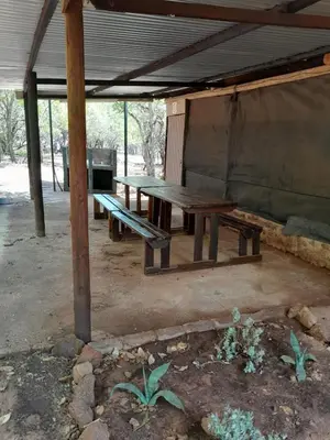 a picnic table sitting under a tent in a field at Shala Mushe Tented Camp & Camp in Bela-Bela
