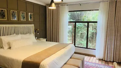 a bedroom with a large bed and a large window at Riverside's Kaia in Dudu