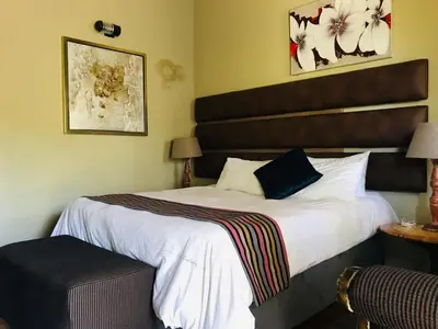 a hotel room with a large bed with a headboard at Riverside's Kaia in Dudu