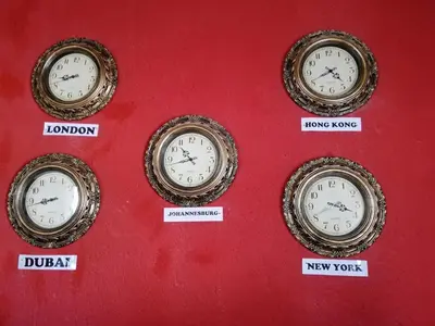 four clocks on a red wall with different time zones at Riverside's Kaia in Dudu