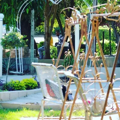 a group of chairs sitting in a garden at Riverside's Kaia in Dudu