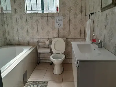 a bathroom with a toilet and a tub and a sink at RS GARDEN GUESTHOUSE in Thohoyandou