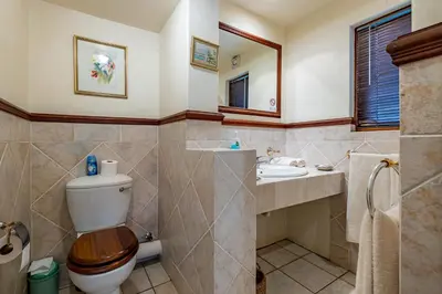 a bathroom with a toilet and a sink at Mhlati Guest Cottages in Malelane