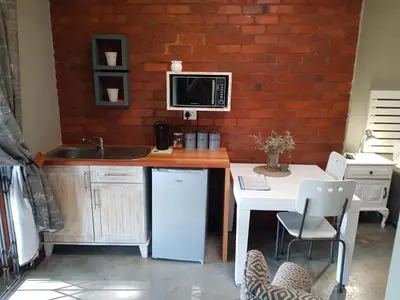 a kitchen with a counter with a microwave and a table at El-Ruze in Baviaanspoort