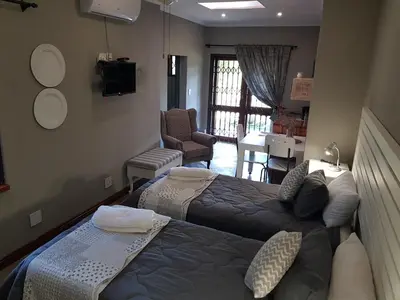 a bedroom with two beds and a living room at El-Ruze in Baviaanspoort
