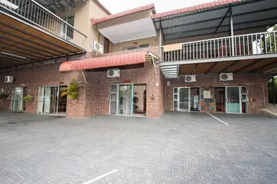 a brick building with a parking lot in front of it at Ingwe Guesthouse in Nelspruit