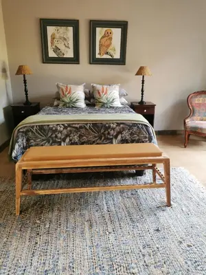 a bedroom with a bed with a bench at the end of it at Rustic Country Cottage in White River