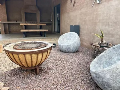 a patio with a table and two large rocks at Buffalo Ranch Game Lodge in Groblersdal