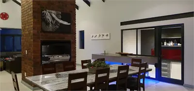 a dining room with a table and a fireplace at Highland Gate House 1023 in Dullstroom