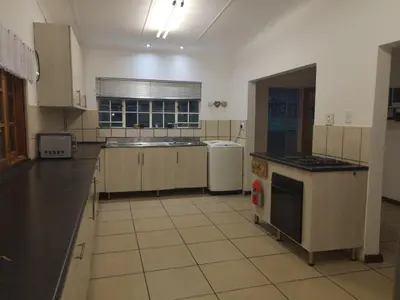 a large kitchen with a sink and a stove at Windsor Cottage in Barberton