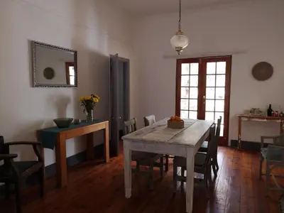 a dining room with a wooden table and chairs at Windsor Cottage in Barberton