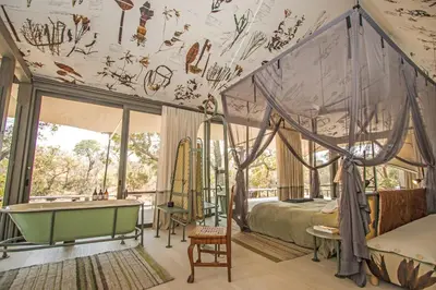 a bedroom with a bed and a tub in it at Saseka Tented Camp in Hoedspruit
