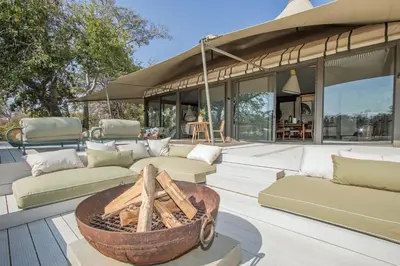 a patio with couches and a fire pit at Saseka Tented Camp in Hoedspruit