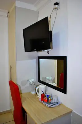 a desk with a mirror and a tv on a wall at Lapologa Bed & Breakfast in Tzaneen