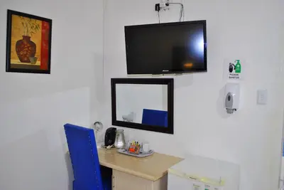 a room with a desk with a mirror and a tv on the wall at Lapologa Bed & Breakfast in Tzaneen