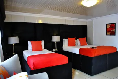 a hotel room with two beds with red pillows at Lapologa Bed & Breakfast in Tzaneen