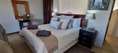 a bedroom with a large bed with two towels on it at Watershed Guest House in Hartbeespoort
