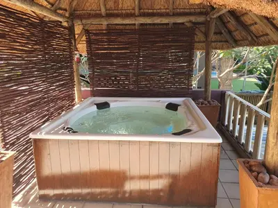 a hot tub in a gazebo on a patio at Watershed Guest House in Hartbeespoort