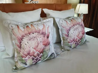 two pillows sitting on top of a bed at Watershed Guest House in Hartbeespoort
