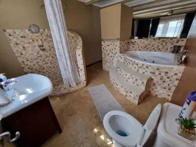a bathroom with a tub and a toilet and a sink at Watershed Guest House in Hartbeespoort