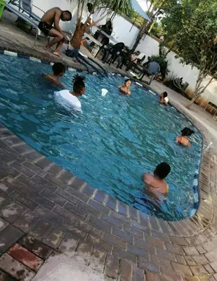 a group of people swimming in a swimming pool at Phokela Guest House in Mokopane