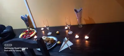 a table topped with a plate of food and candles at Phokela Guest House in Mokopane