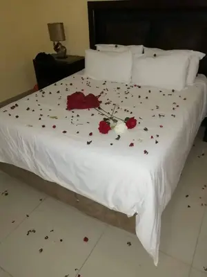 a white bed with flowers on it at Phokela Guest House in Mokopane