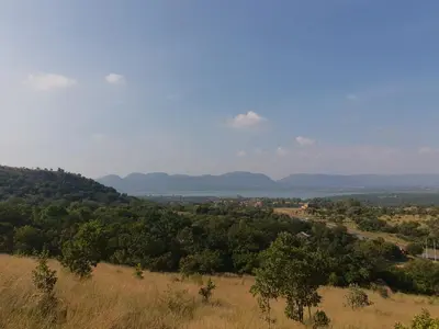 a view of a field with mountains in the distance at The Farm in Hartbeespoort