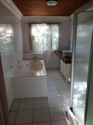 a white bathroom with a tub and a sink at The Farm in Hartbeespoort