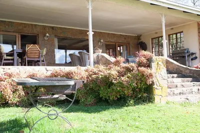 a house with a picnic table in the yard at Connemara Trout Lodge in Dullstroom
