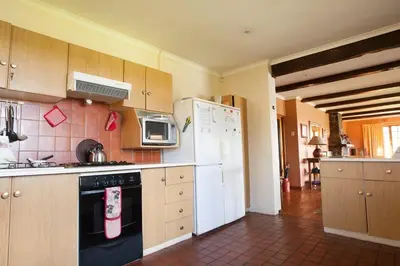 a kitchen with a stove and a white refrigerator at Connemara Trout Lodge in Dullstroom
