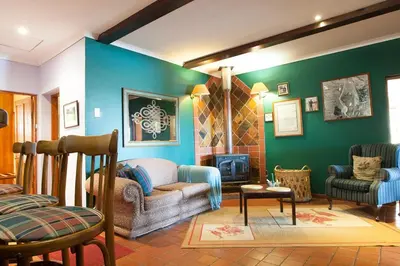 a living room with a couch and a chair at Connemara Trout Lodge in Dullstroom