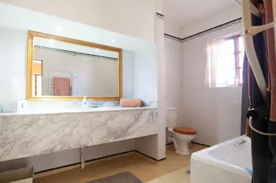 a bathroom with a tub and a sink and a toilet at Connemara Trout Lodge in Dullstroom