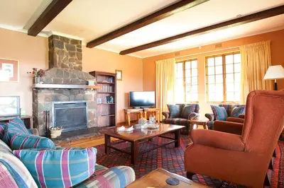 a living room with couches and a fireplace at Connemara Trout Lodge in Dullstroom