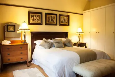 a bedroom with two beds and a dresser and two lamps at Brooks Cottage in Pretoria