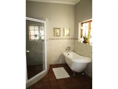 a bathroom with a bath tub and a shower at Brooks Cottage in Pretoria