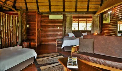 a living room with two beds and a couch at Elephant Walk Retreat in Komatipoort