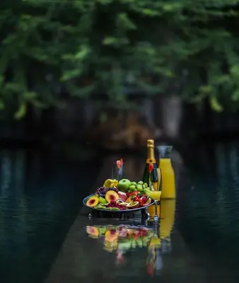 a plate of fruit on a table in the water at Khaya Ndlovu Safari Manor in Hoedspruit