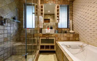 a bathroom with a shower and a tub and a sink at Khaya Ndlovu Safari Manor in Hoedspruit