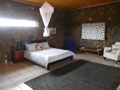 a bedroom with a dog laying on a bed at Adonsonia Lodge in Grietjie Nature Reserve