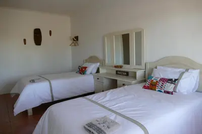 a hotel room with two beds and a mirror at Adonsonia Lodge in Grietjie Nature Reserve