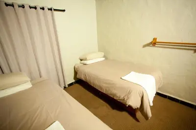 a hotel room with two beds and a window at Umuzi Lodge in Secunda