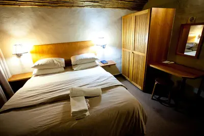 a hotel room with a bed with two towels on it at Umuzi Lodge in Secunda